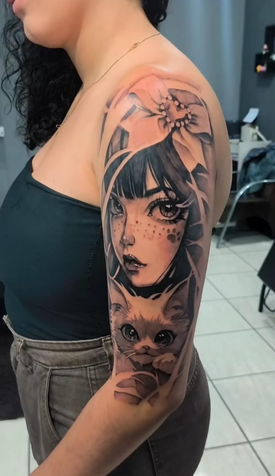 Tatuagem grande no braço com personagem autoral e gato